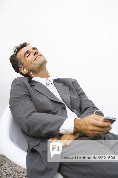 Geschäftsmann entspannt  MP3-Player hören  mit geschlossenen Augen lächeln