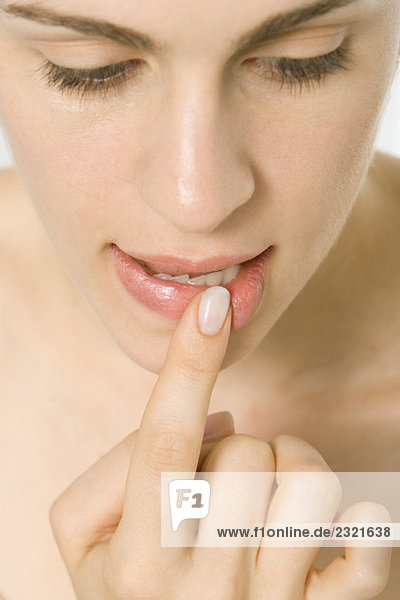Woman holding finger to lip  close-up of face mouth