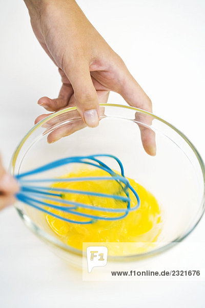 Frau verquirlt Eier in der Schüssel  geschnitten  Hochwinkelansicht