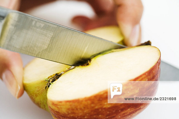Frau schneidet Apfel mit Messer  Nahaufnahme  abgeschnittene Handansicht