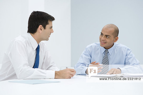 Two businessmen sitting at table having meeting