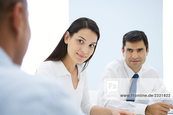 Business associates having meeting  focus on young woman in middle ground