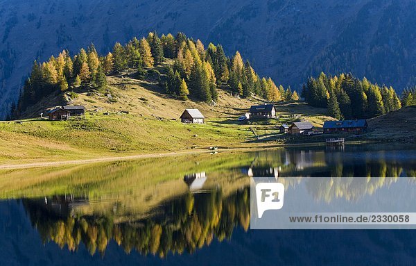 Reflexion von Bäumen und Gartenhäuser in Wasser, Duisitzkarsee, Niedere Tauern, Österreich