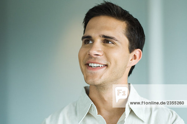 Young man smiling  looking away  portrait