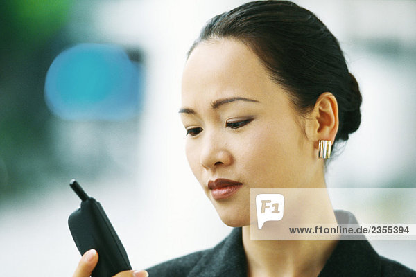 Businesswoman looking down at cell phone  close-up
