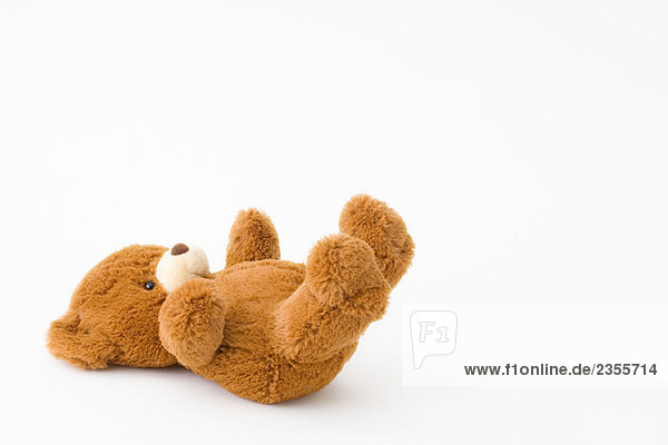 Teddybär auf dem Rücken liegend
