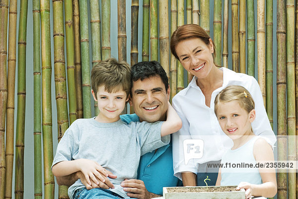 Familie lächelt gemeinsam vor Bambus  Gruppenbild