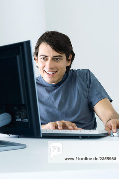 Mann mit Desktop-Computer  lächelnd