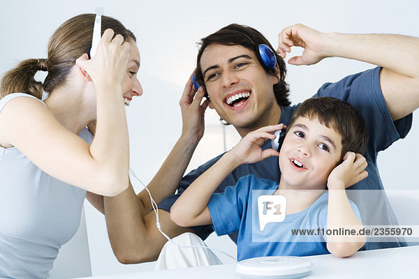 Family listening to CD player together  father and son using wireless headphones