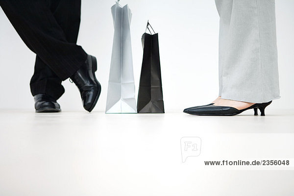 Paar stehend mit Einkaufstaschen dazwischen  abgeschnittene Ansicht der Füße  flache Ansicht