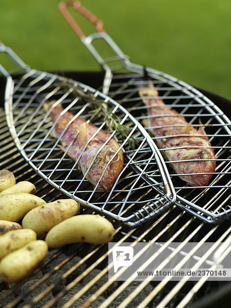 Close-up of fish and sausages on barbecue grill
