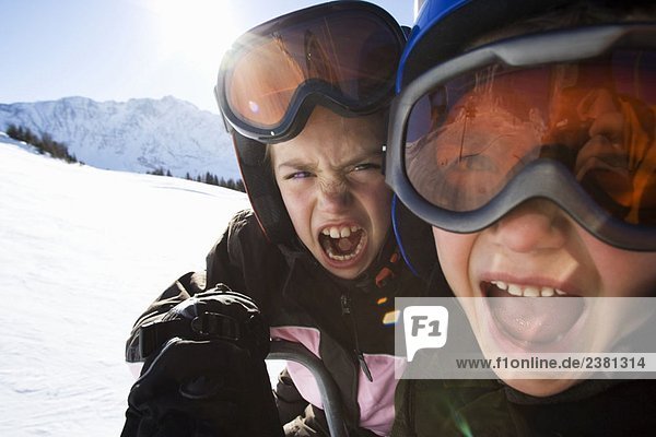 Kinder in Skihelmen und Skibrille