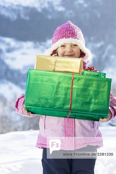 Porträt eines Mädchens mit Geschenken im Schnee