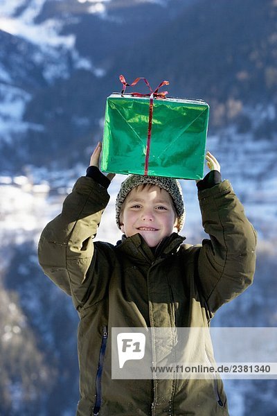 Junge mit Geschenk im Schnee