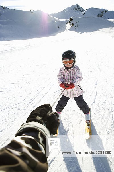 Young girl being towed on skis