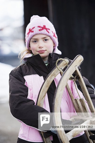 Porträt eines jungen Mädchens mit Schlitten