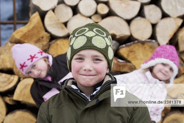 Kinder posieren mit Winterhüten auf dem Kopf