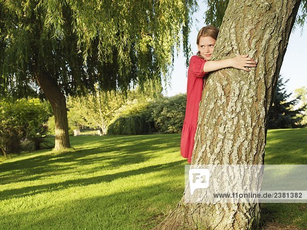 Junges Mädchen umarmt Baum