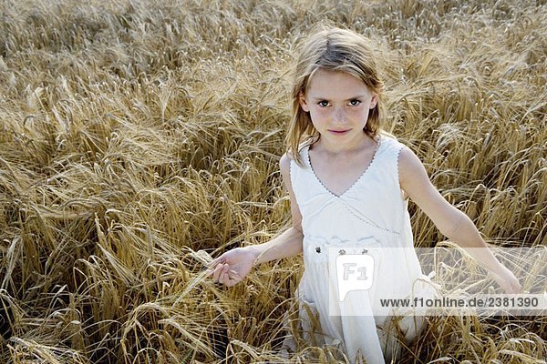 Young girl walking in corn field