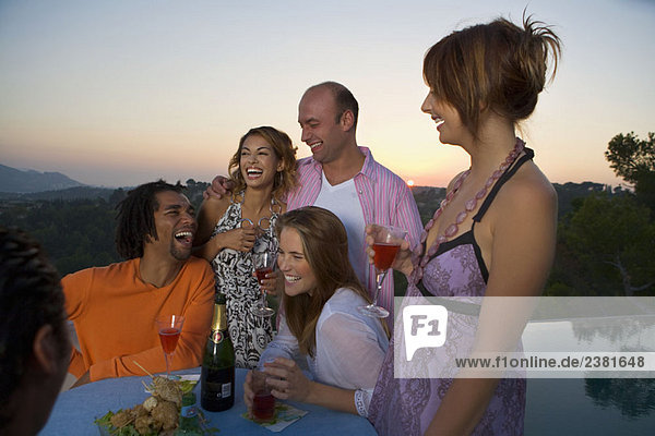 Männer und Frauen auf einer Party bei Sonnenuntergang