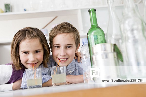 Junge und Mädchen trinken Limonade  lächelnd