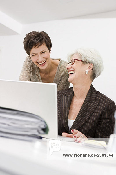 Zwei Frauen lachen vor einem PC