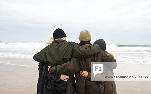 Gruppe von Freunden  die sich am Strand umarmen