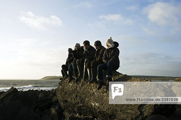 Gruppe von Freunden auf dem Felsen sitzend