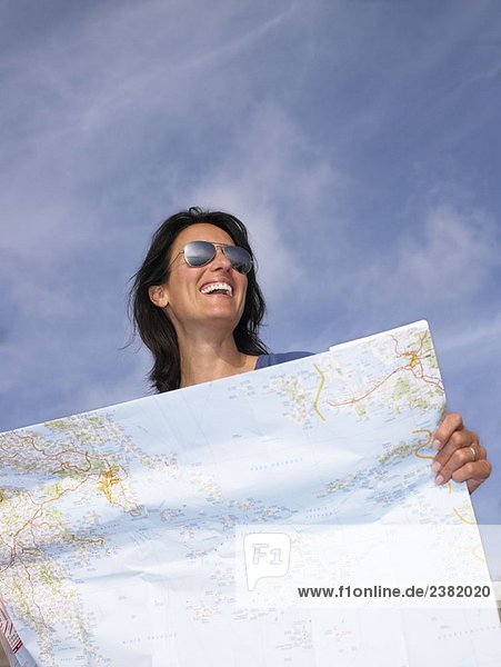 Frau schaut auf eine Landkarte  lacht