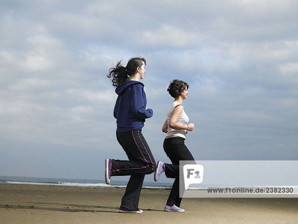 Two young females jogging on beach