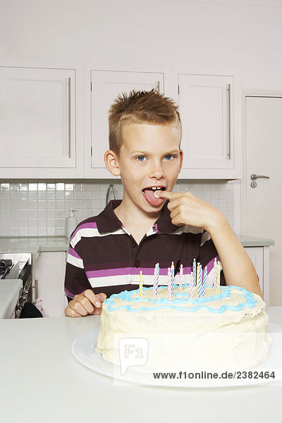 Junge leckt Kuchenglasur