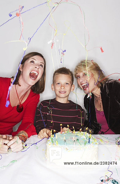 Frauen und Junge mit Geburtstagskuchen