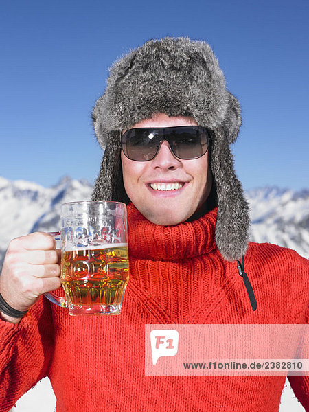 Junger Mann beim Trinken in den Bergen