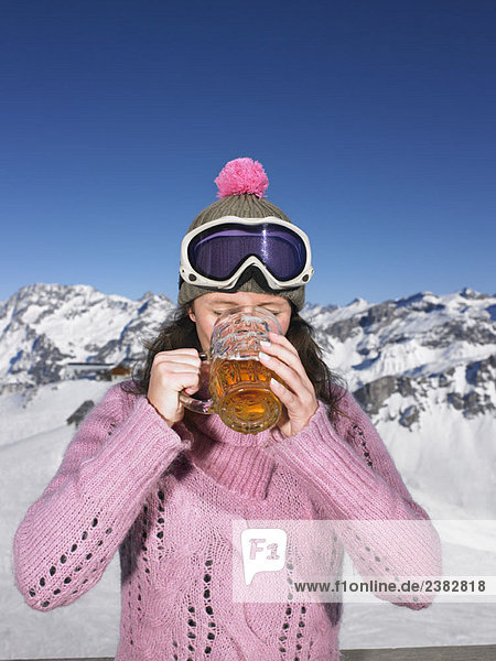 Junge Frau beim Trinken in den Bergen