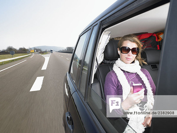 Junge Frau hört Musik im Auto