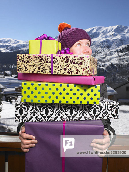Young woman holding pile of presents