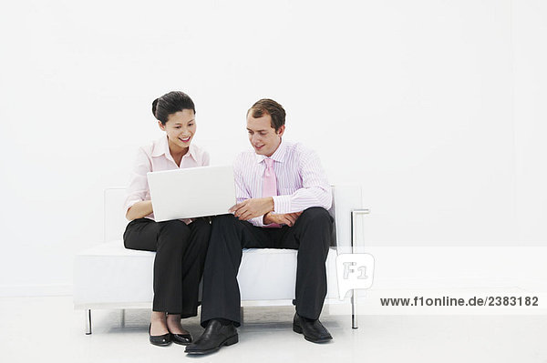 Man and woman smiling at laptop