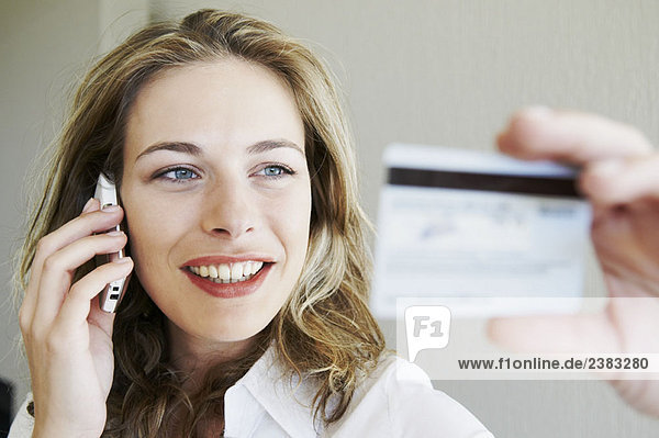 Woman on phone  looking at credit card