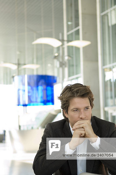 Businessman sitting in an office with his hands clasped