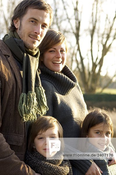 Porträt von zwei Kindern  die mit ihren Eltern lächeln