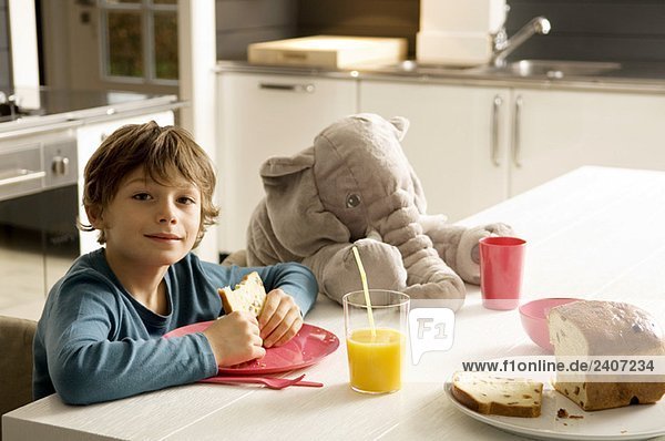 Portrait eines Jungen beim Frühstück in der Küche