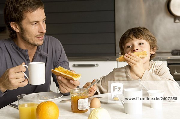 Mid adult man having breakfast with his son
