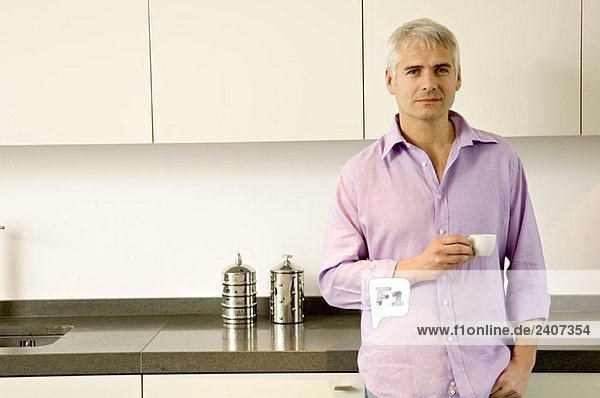 Porträt eines reifen Mannes mit einer Tasse Tee in der Küche