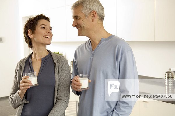 Ein reifer Mann und eine erwachsene Frau mit Milchgläsern.