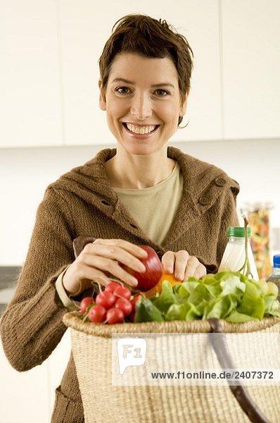 Porträt einer erwachsenen Frau  die in der Küche lächelt.