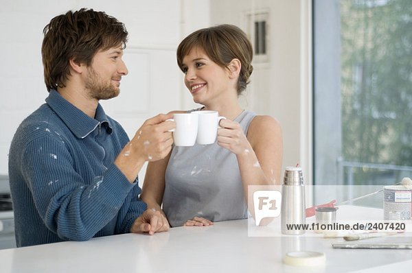 Couple holding cups of tea and smiling