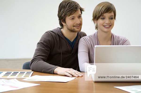 Mid Erwachsenen Mann und eine junge Frau mit einem Laptop und lächeln
