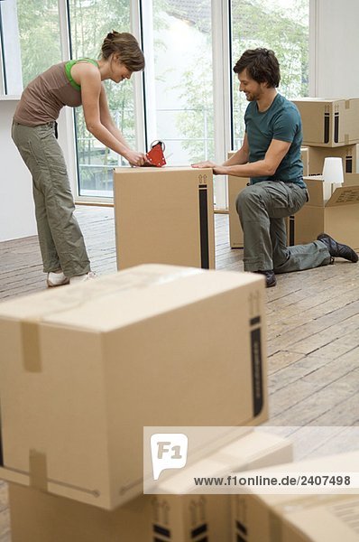 Couple packing cardboard boxes