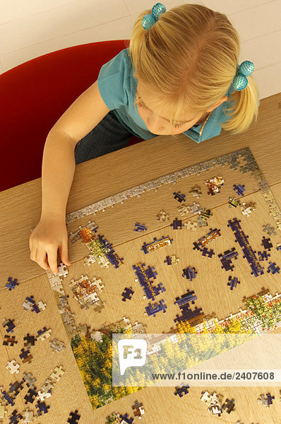 Hochwinkelansicht eines Mädchens beim Puzzlespielen