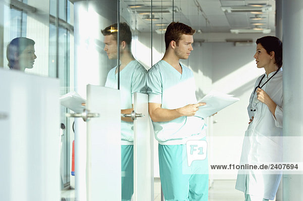 Side profile of two doctors discussing a medical record